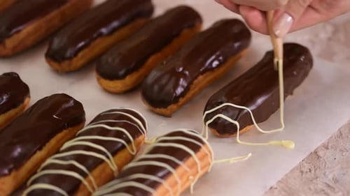 Icing Decorated Chocolate Eclairs in Close Up