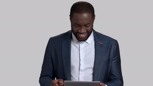 Man in Blazer Uses Tablet with Smile