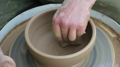 Potter Forming Clay Bowl with Sponge on Wheel
