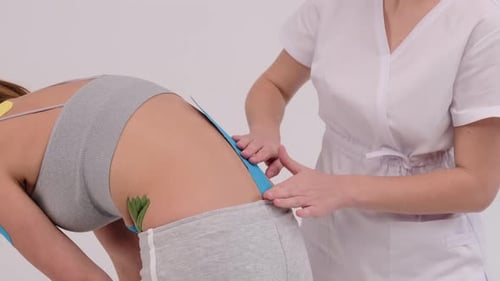 Medical Professional Applying Colorful Kinesiology Tape to Patient
