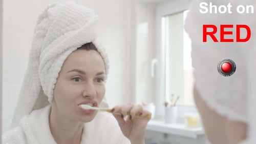 Woman Brushing Teeth in Bathroom Mirror, Morning Routine