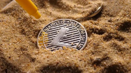Litecoin in Sand Near Toy Shovel