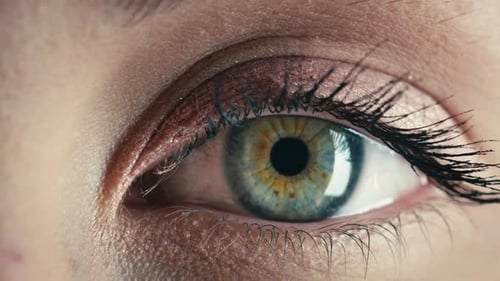 Ojo azul de una hermosa chica modelo que se abre lentamente