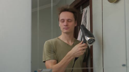Young Man Drying Hair with Hair Dryer