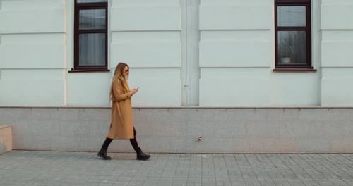 Woman with Smartphone Walking in the City