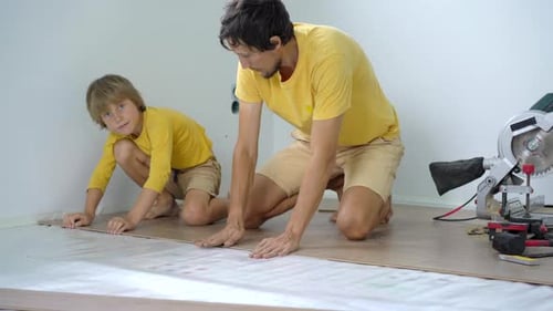 Man and Child Laying Wooden Flooring Together