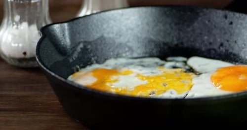 The Frying Pan with Fried Eggs Slowly Rotates on Table.