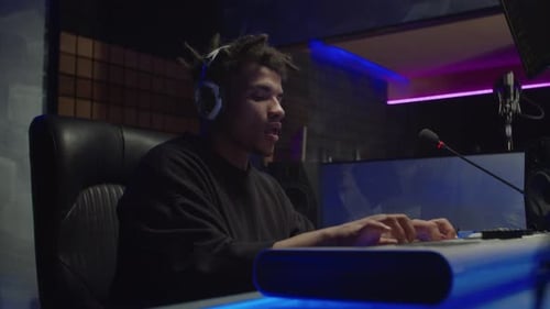Professional African American Male Musician Playing Digital Piano Creating New Song in Music Studio