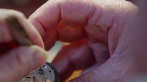 Close-up of horologist hands repairing a watch