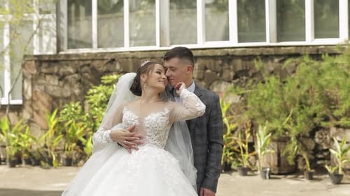 Newlyweds. Caucasian Groom with Bride Walking, Embracing, Hugs in Park. Wedding Couple
