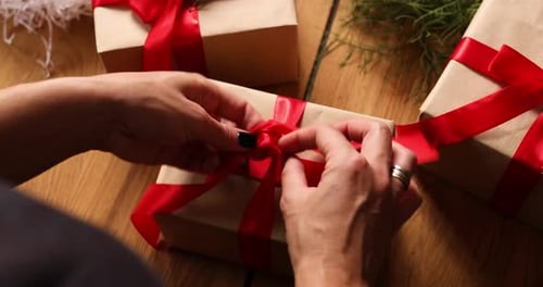 Hands of cropped unrecognisable woman packing Christmas present, Eco friendly packaging