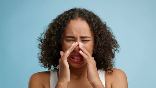 Woman Presses Nose in Painful Close-Up Shot