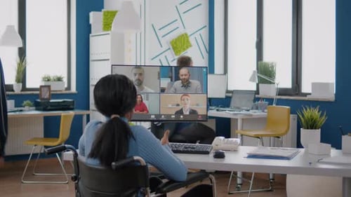 Woman in Wheelchair at Virtual Meeting in Modern Office