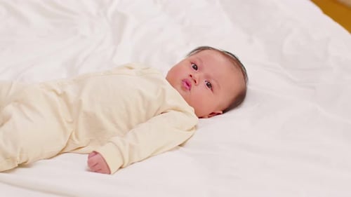 Adorable Infant Lying on Blanket, Smiling and Looking