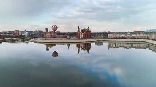 City panorama. A clear reflection of the promenade and balloon in the calm river