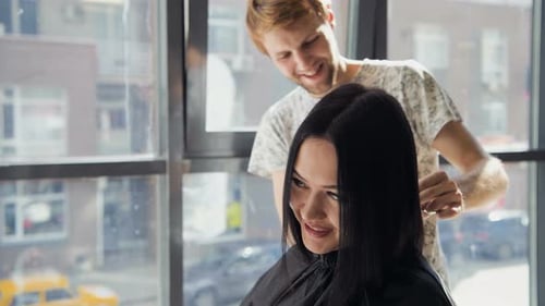 Hairdresser Styling Woman's Hair in Bright Salon