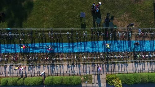Triathlon Racers Run and Take their Bikes to Start Cycling Stage