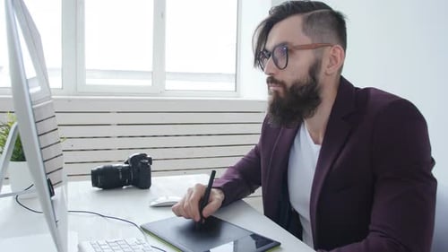 Man Working at Computer with Stylus and Tablet