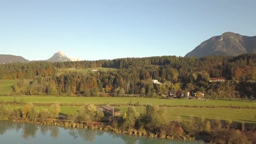 Aerial view of green meadows with villages and forest in austrian Alps mountains