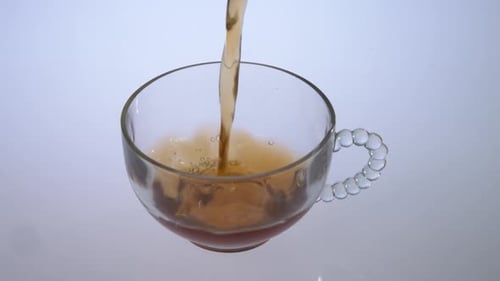 Pouring Tea into a Clear Glass Teacup