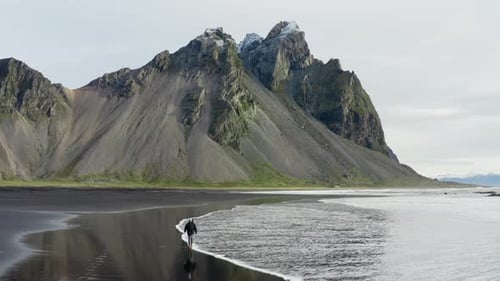Drone Of Man On Black Beach Under Vestrahorn Mountain