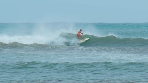 Young Man with Long Hair Rides the Ocean Wave at the Mauritius Surf Spot