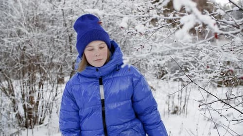 Curious Young Girl Walking Through Winter Forest