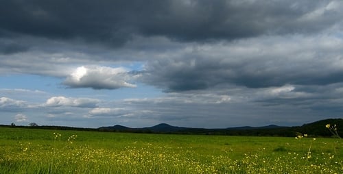 Scenic Green Meadow with Dramatic Cloudy Sky