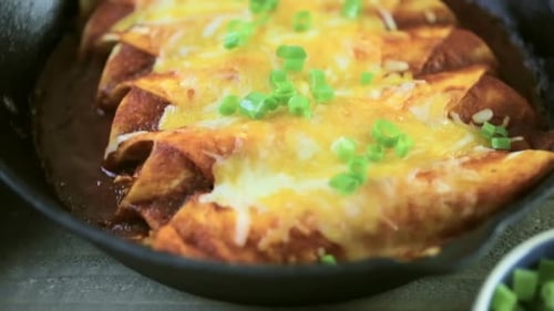 Delicious Enchiladas Topped with Cheese and Green Onions