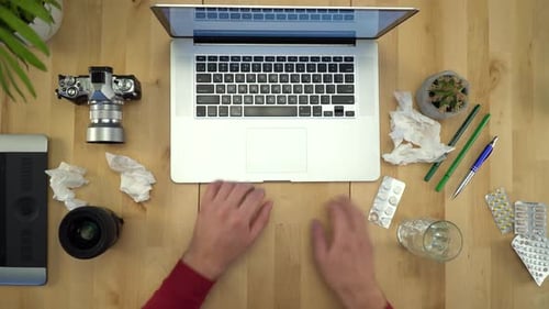 Hombre enfermo trabajando en la computadora en el lugar de trabajo