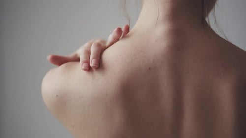 Woman Touching Her Bare Shoulder and Neck
