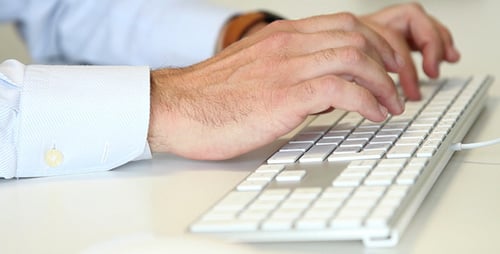 Adult Typing on Keyboard in Office Setting