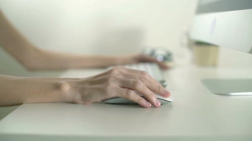 Woman Typing on Keyboard Using Computer Mouse