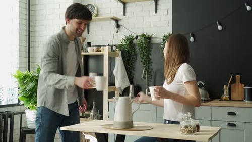 Couple Talking and Drinking Coffee in Kitchen