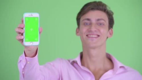 Young Adult Man Holds Smartphone with Green Screen