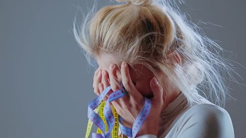 Distressed Woman with Measuring Tape Wrapped Around Hands