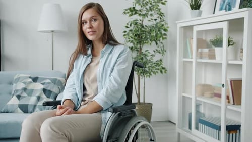 Young Woman Sitting in Wheelchair At Home