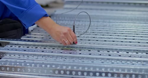 Un employé de l'usine vérifie la qualité du métal à l'aide d'un capteur, la qualité du métal