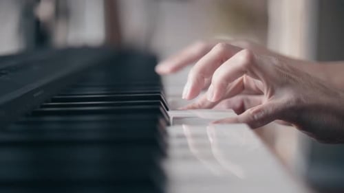 Hands Playing Piano Keys in Close Up