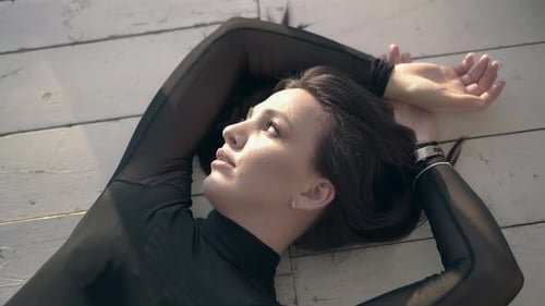 Woman Lies on White Wooden Floor in Sunlight