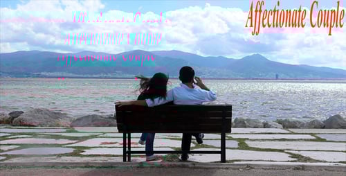 Couple Relaxing on Bench Overlooking Lake and Mountains