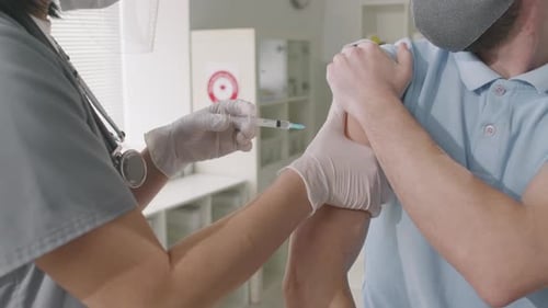 Doctor Administers Injection to Patient in Clinic