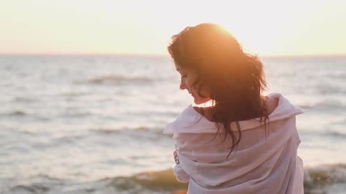 Woman with Wavy Hair on Beach at Sunset