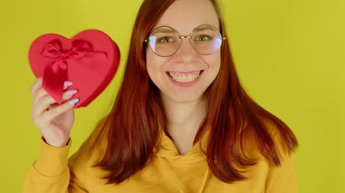 Smiling Woman Holding Heart Shaped Gift Box