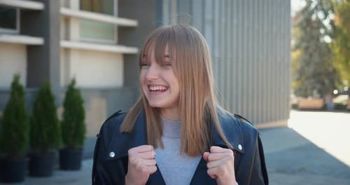 Excited Young Woman Celebrates in Urban Setting