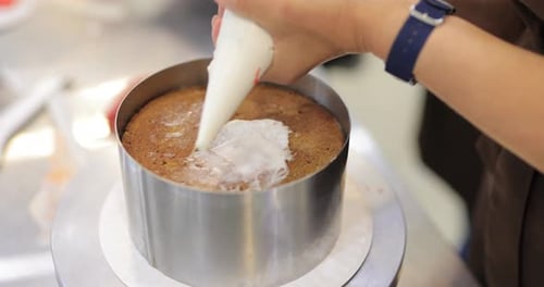 Icing Being Piped Onto Cake on Rotating Platform