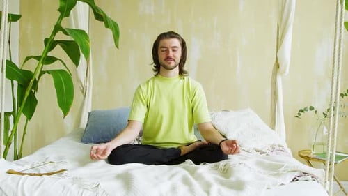 Man Meditating on Bed in Lotus Position