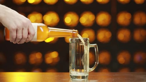 Beer Bottle Pouring Into Mug at the Bar