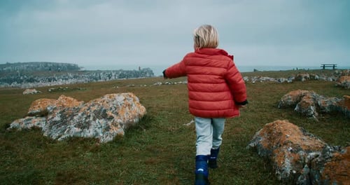 Children Walk on Meadow Pointing with Hand to the Ocean on Vacation Travel