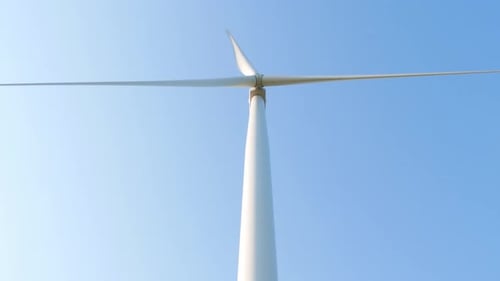 Wind turbine rotating on clear blue sky Local eco friendly powerful converter farm generating energy